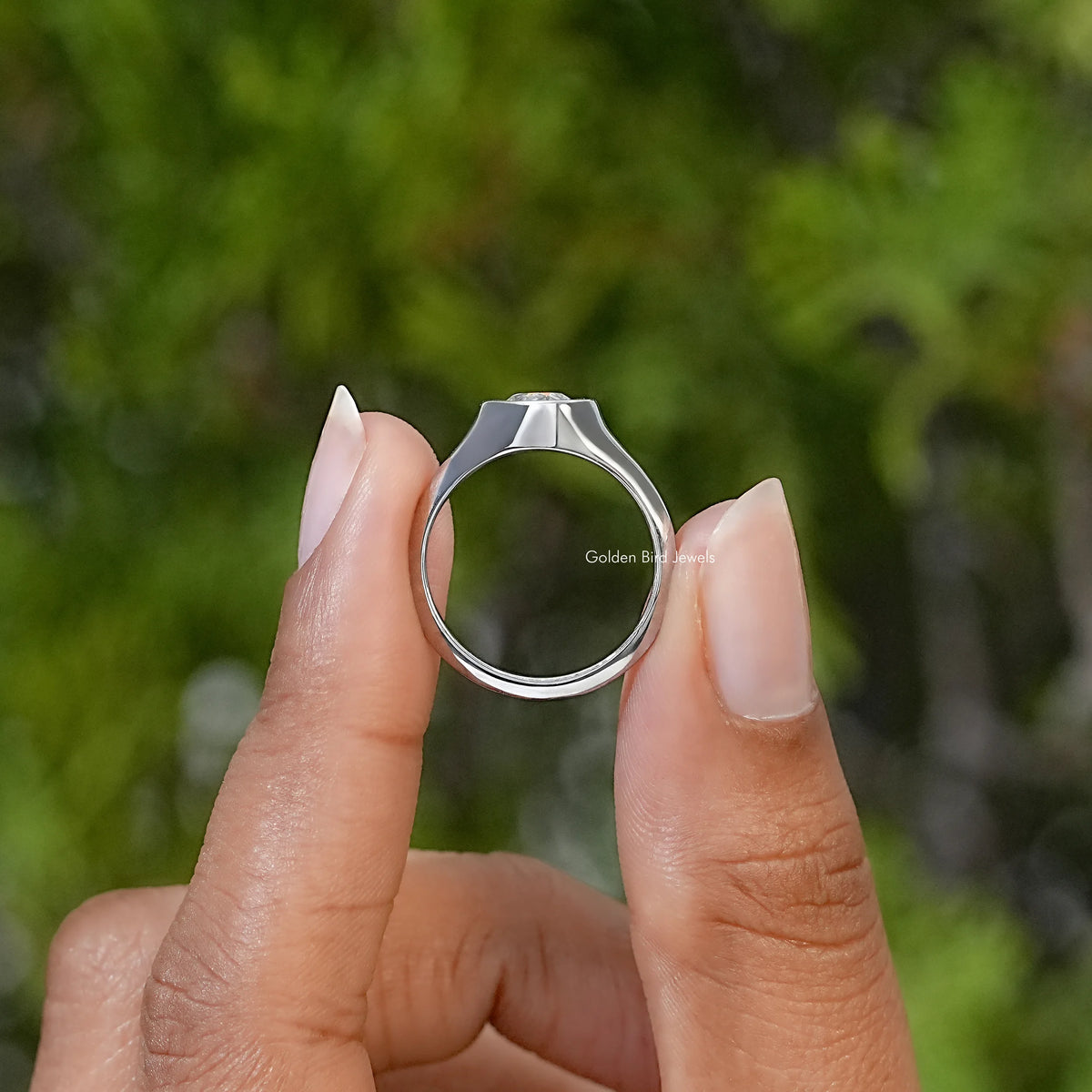 Men's silver engagement ring shown from the side, highlighting its band and raised stone setting