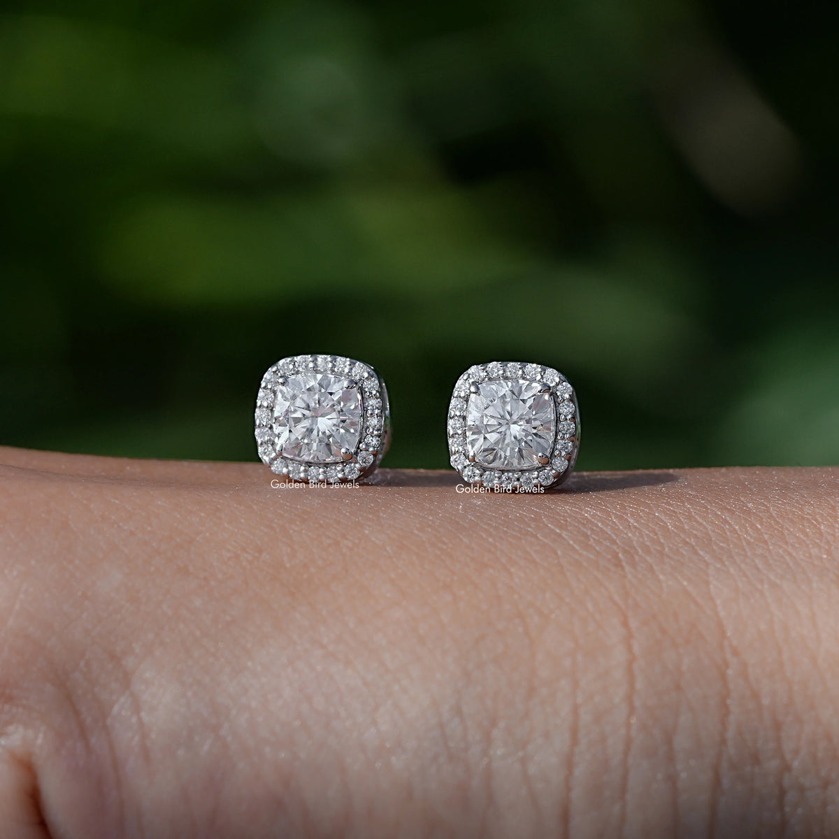 In Hand View Of a cushion cut moissanite stud Earring