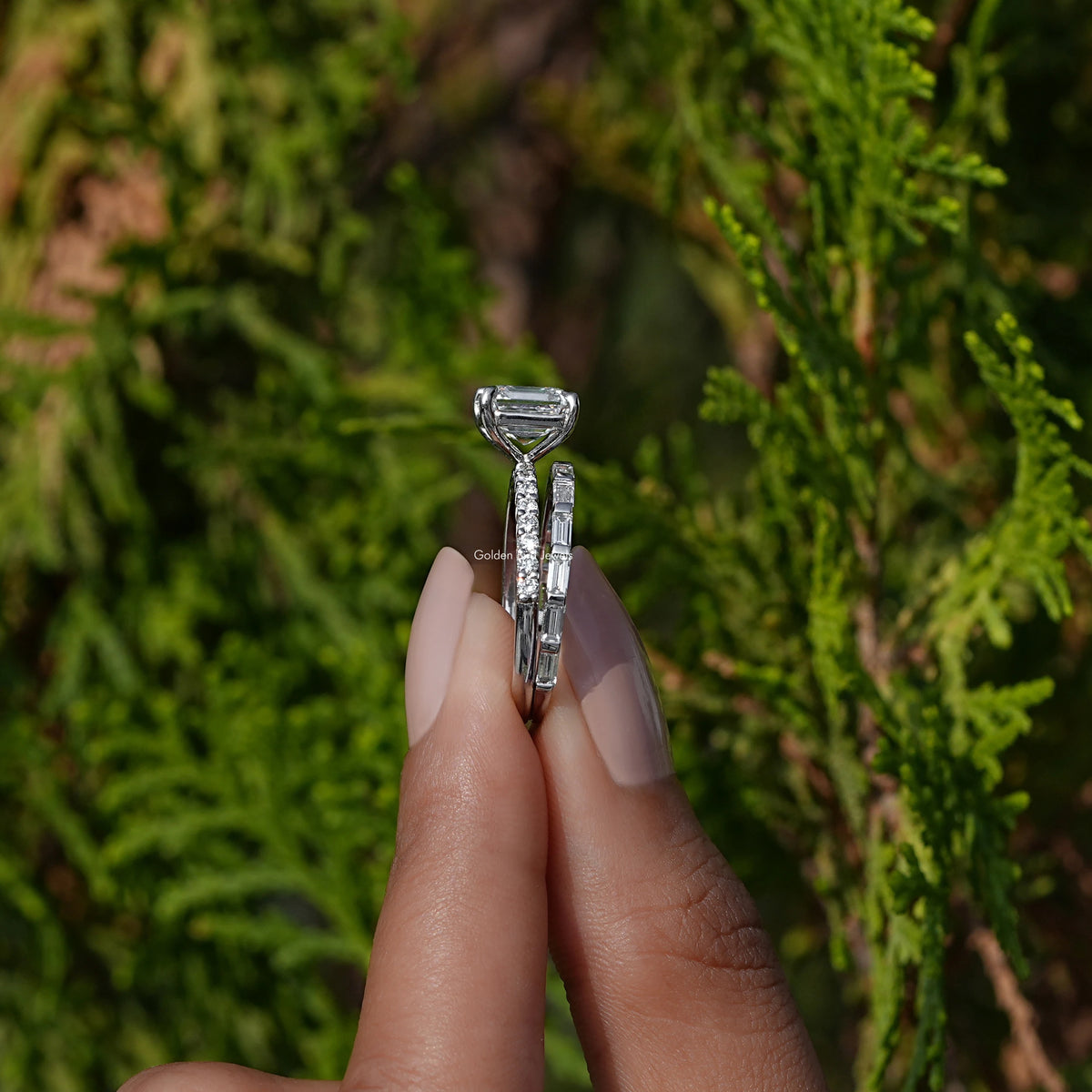 Side View A Emerald Cut Diamond Wedding Ring Set in two fingers