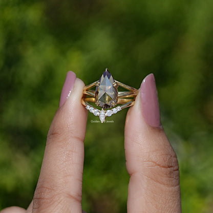 Pear-cut moissanite bridal ring set with pavé band in yellow-toned metal
