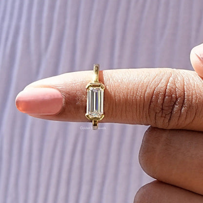 Emerald-cut solitaire ring side view, gold-tone setting with rectangular stone