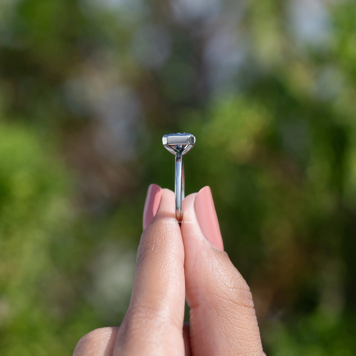 Sterling silver moissanite ring showing half bezel prongs over a square-cut center stone