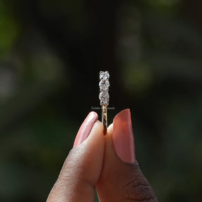 Side View of Oval Cut Lab Diamond Eternity Wedding Band In two fingers