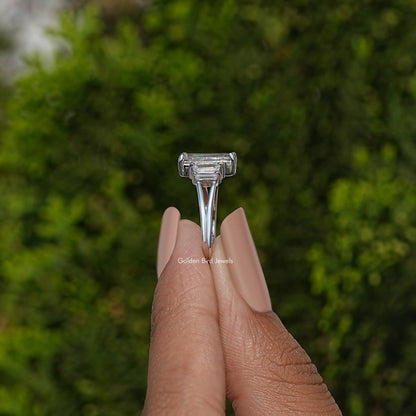 Split shank ring showing centered emerald-cut stone setting, silver tone
