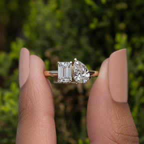 Emerald and Pear Lab Diamond Toi Et Moi Ring Held Between Fingers