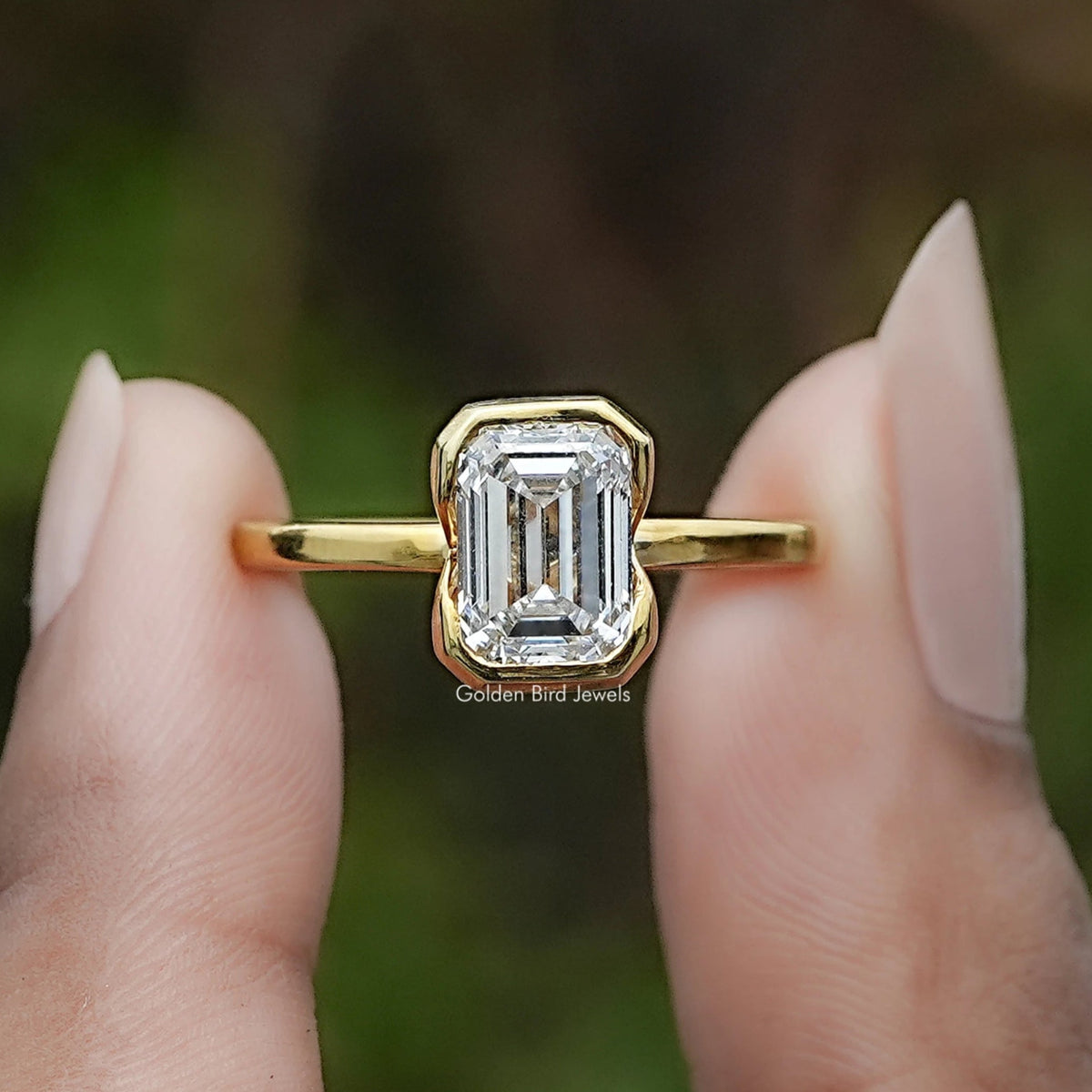 Emerald Cut Lab Diamond Bezel Set Solitaire Ring In Two Fingers