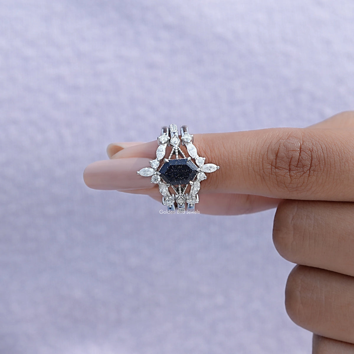 Dark blue center bridal ring with marquise and round white stones, hand close-up