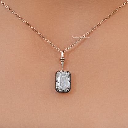 Solitaire pendant necklace with a clear emerald-cut stone, dark setting, and fine chain