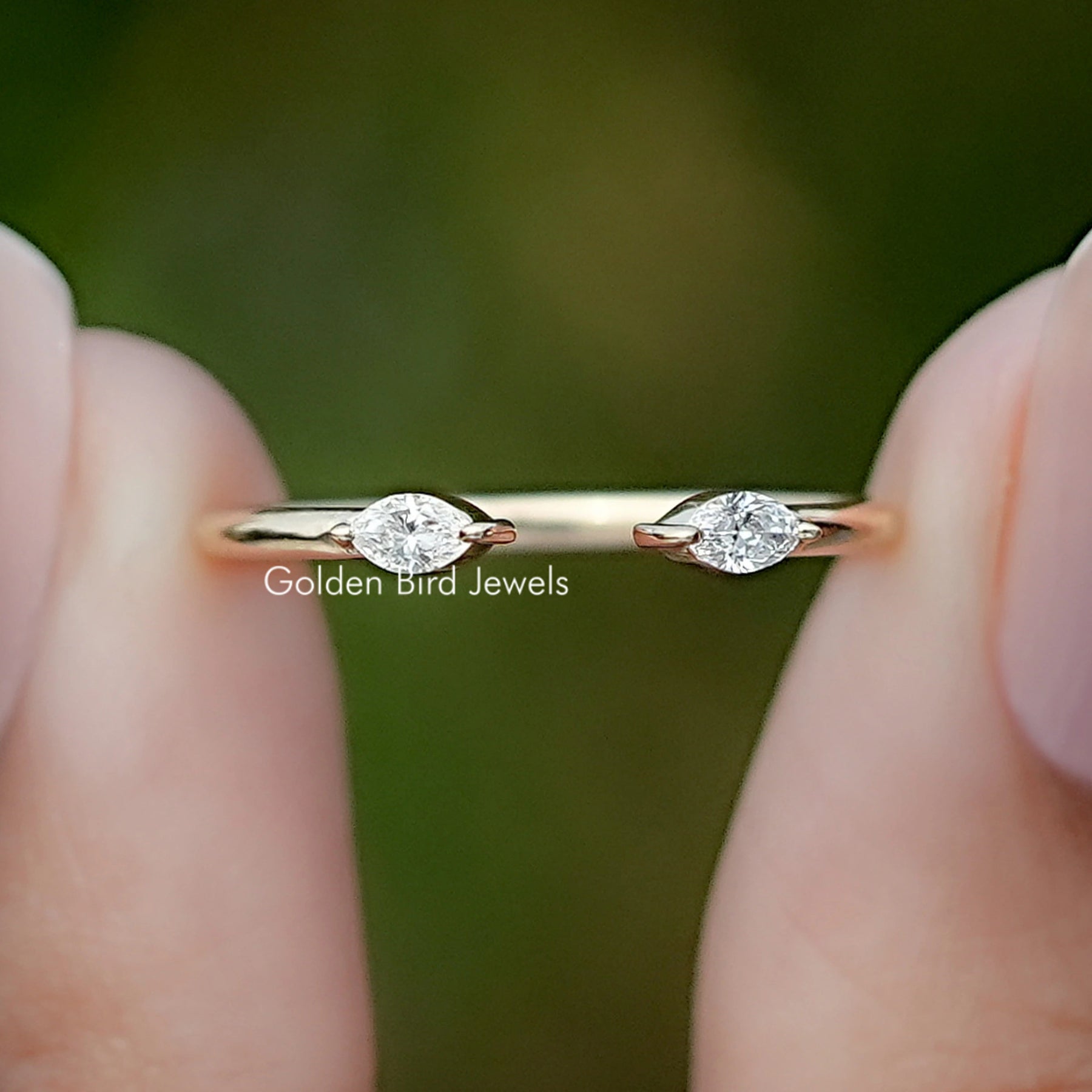 Marquise Cut Lab Diamond Open Cuff Two Stone Ring Held Between Fingers