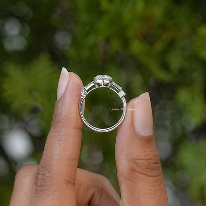 Sterling silver ring shown from the side, with raised round and baguette stones