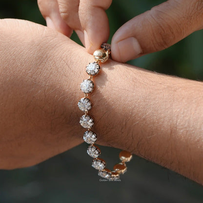 In Finger holding view of round cut moissanite tennis bracelet