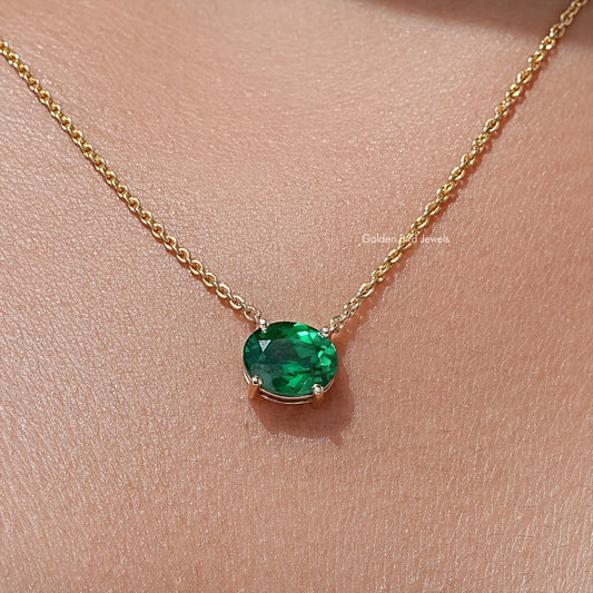 Oval lab-grown diamond solitaire pendant with green oval gemstone on gold-tone chain