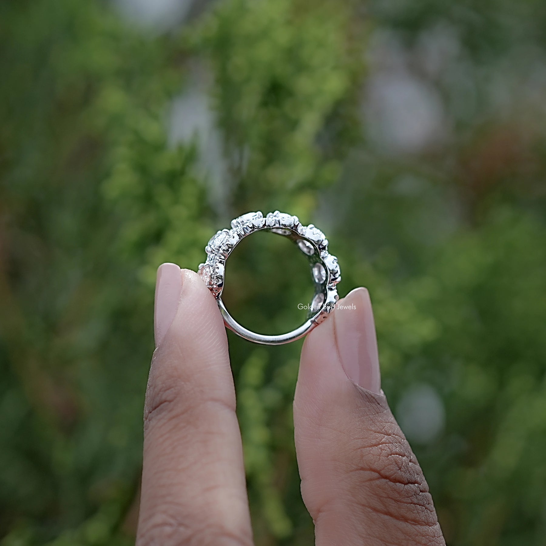 Back view of Oval Cut Diamond Seven Stone Band Held in Finger