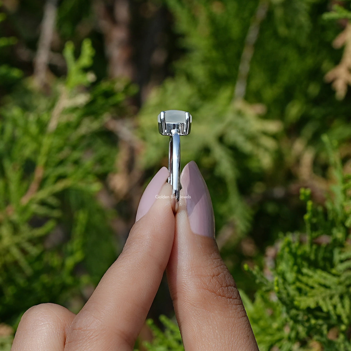 Side View of Oval Moonstone Gemstone Solitaire Ring In two fingers