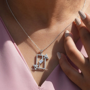 In neck front view of round and emerald cut white gold pendant