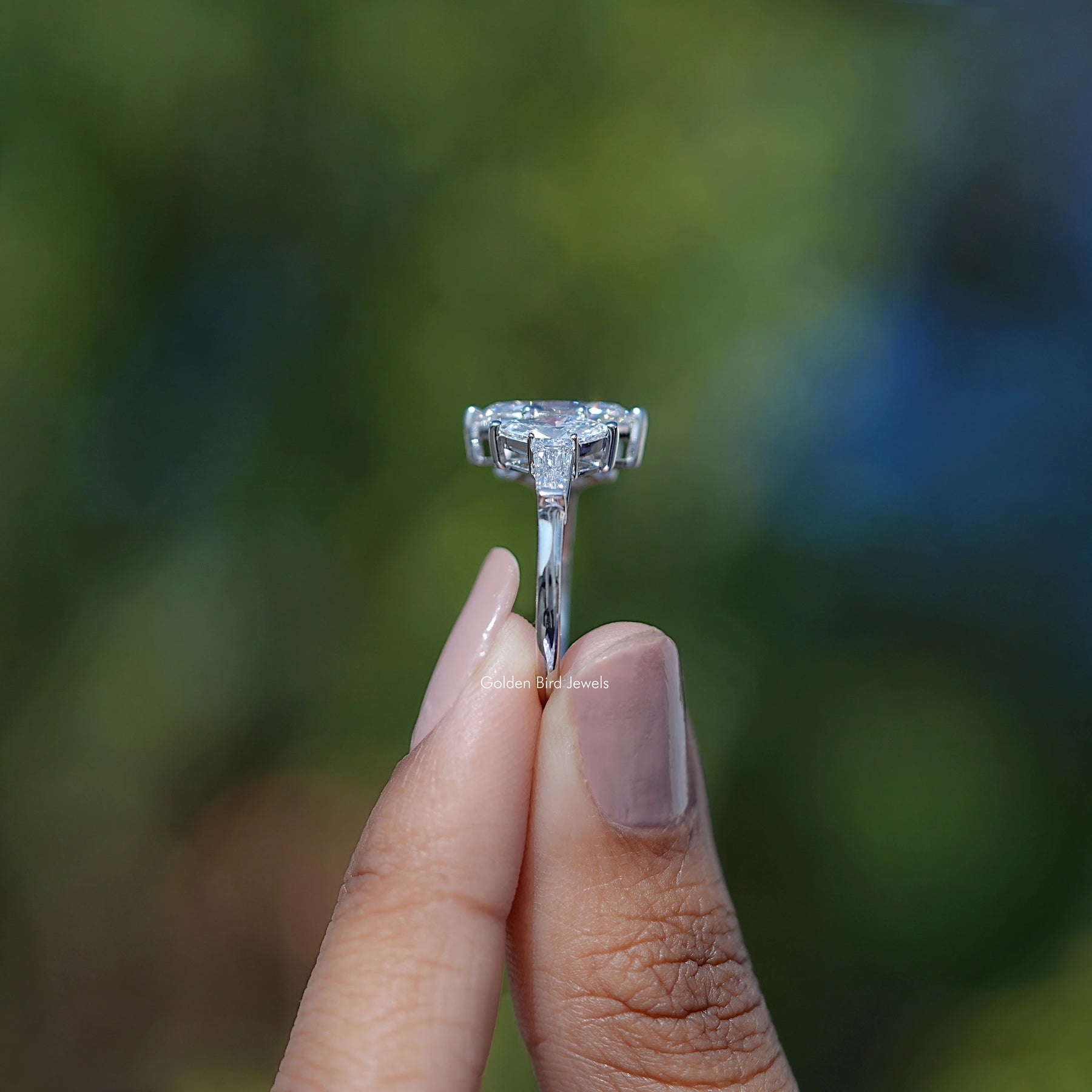 Side View of Baguette Cut Diamond Five Stone Ring In two fingers